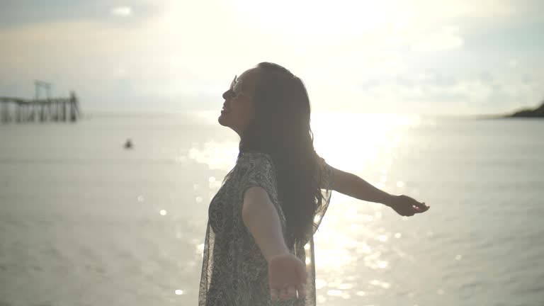 Asian Woman on beach with opening arms