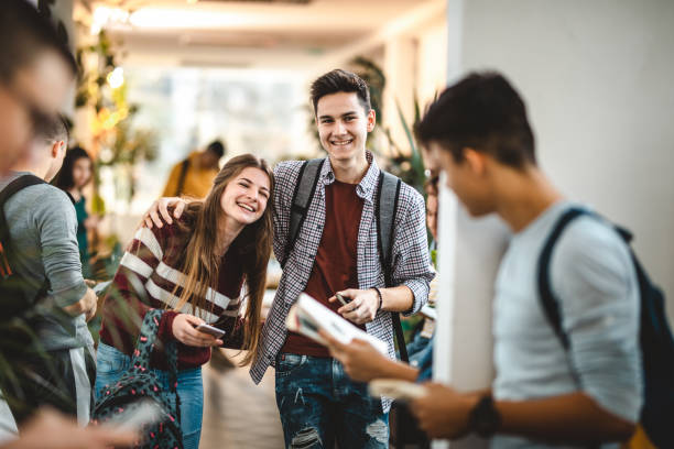istock Happy high school couple walking through hallway. 1151537135