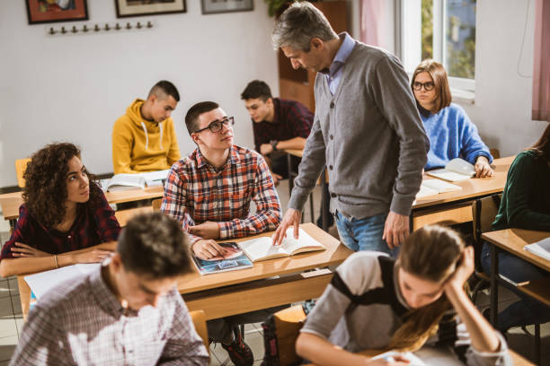 istock Male teacher talking to his students while assisting them on a class. 1151537231