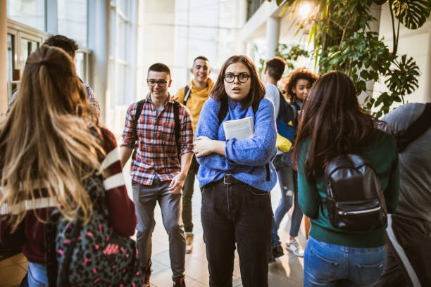 istock Shocked nerdy student among her classmate in a school hallway. 1151538202