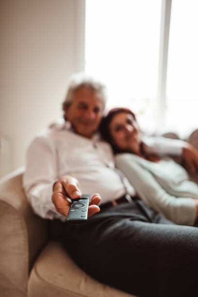 istock senior adult watching tv on the sofa 1151538231
