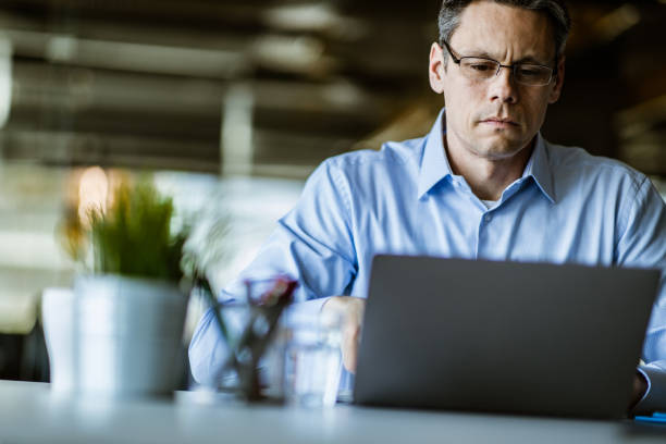istock Mid adult businessman working on a computer in the office. 1151540625