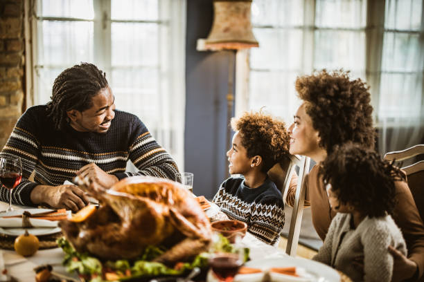 istock Happy black family talking during Thanksgiving meal at dining table. 1151545482
