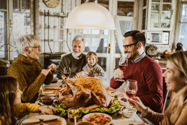 istock Happy extended family talking during Thanksgiving meal at dining table. 1151546770