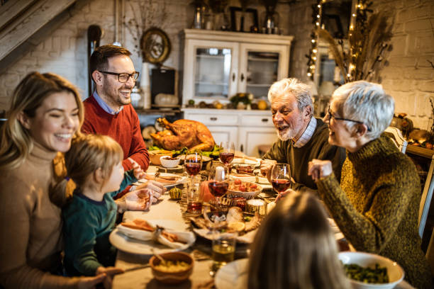 istock Happy multi-generation family communicating while having Thanksgiving lunch in dining room. 1151546973