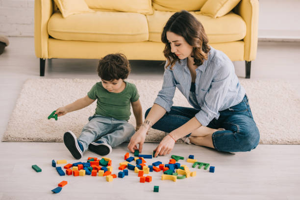 istock Mother and son playing with toy blocks on carpet 1151549573