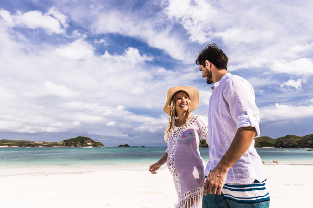 istock Happy pregnant couple talking while walking in summer day on the beach. 1151551576