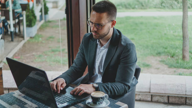 istock Businessman working on laptop in coffee shop 1151556332