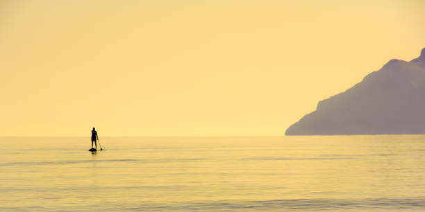 istock Silhouette Man Paddleboarding In Sea Against Clear Sky During Sunset 1151556370