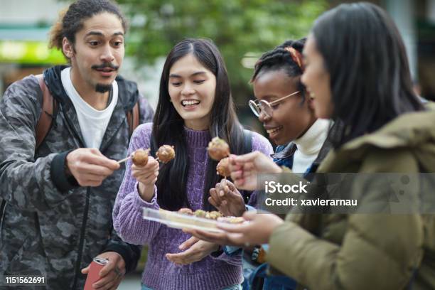 Happy Friends Eating Parcel Takoyaki In City Stock Photo - Download Image Now - Takoyaki, Tourism, Tourist