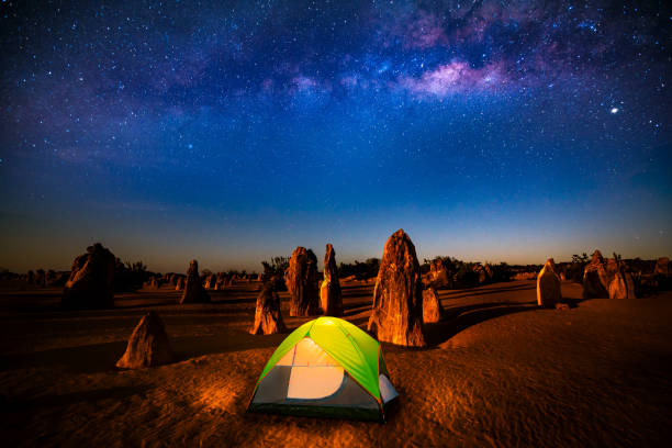 cielo stellato ai pinnacoli, la mungivia si eleva sopra una pietra in piedi - outback desert australia sky foto e immagini stock