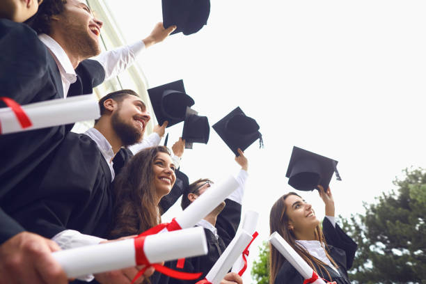 istock Happy graduates raised their hands with scrolls of diplomas 1151567149