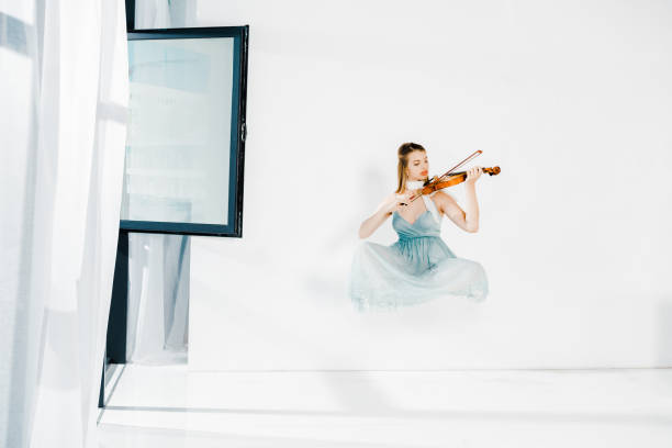 istock floating girl in blue dess playing violin on white background 1151567941