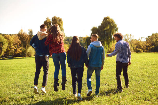 istock Happy friends walking on green meadow 1151568308
