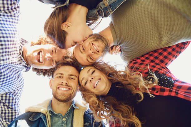 istock Bottom view. Friends hugging and smiling outside 1151568317
