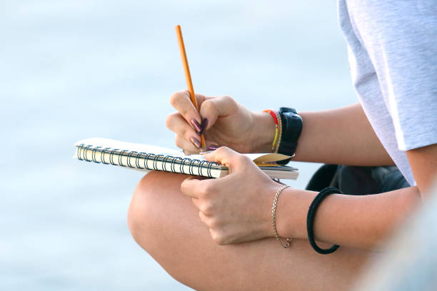 istock girl draws in a notebook sitting on the pavement 1151568687