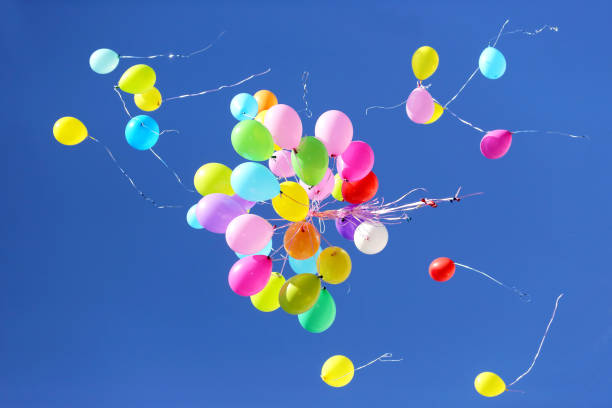istock many multicolored balloons flying in the blue sky 1151571071
