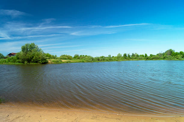 River in rural terrain at spring length of time on background blue sky