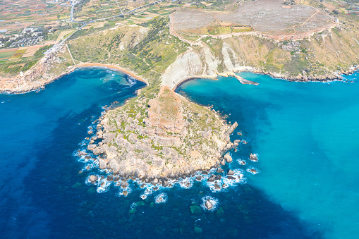 Aerial view from a great height of the coastlinescenic sliffs near the mediterranean turquoise water sea. Gnejna and Ghajn Tuffieha bay on Malta island