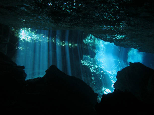 Sun rays entering the water in an underwater cave. stock photo