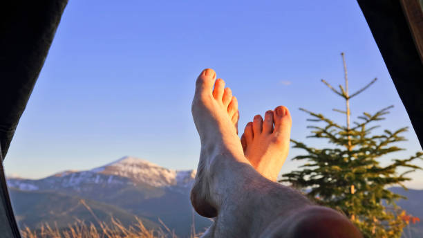 istock bare feet resting camper in tent with mountain view 1151574539