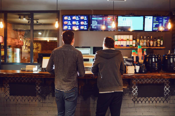 deux hommes choisissent la nourriture dans un restaurant fast-food. - cuisine rapide photos et images de collection