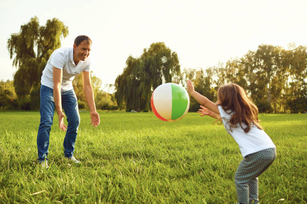 istock Father with a small daughter playing with a ball in nature. 1151576374