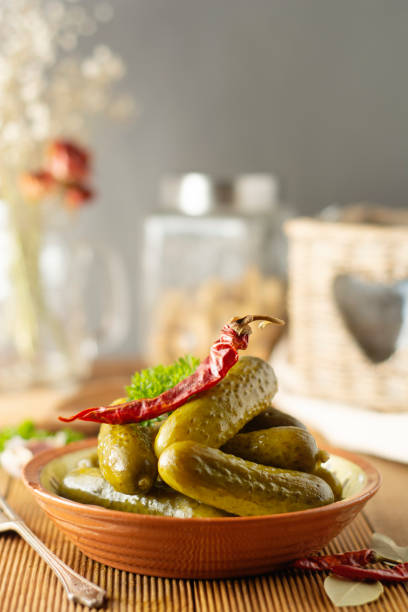 istock Pickled cucumbers in a bowl, rustic wooden background 1151577707
