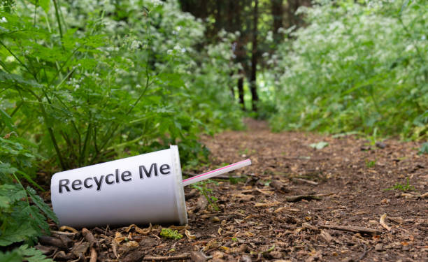 Discarded drink cup with straw pleading to be recycled