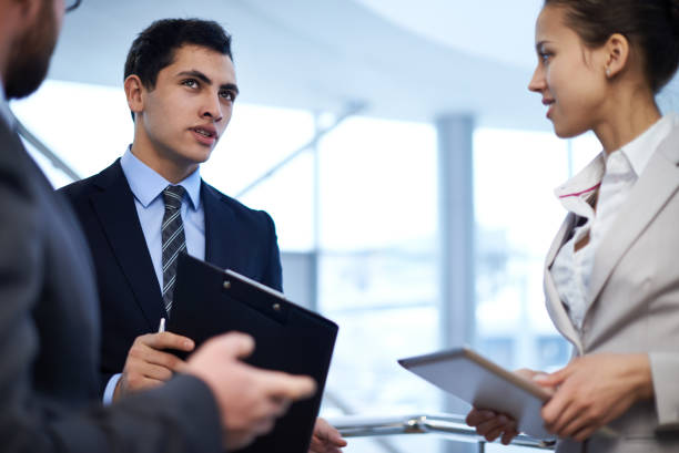 istock Businessman with clipboard speaking with colleagues 1151586869