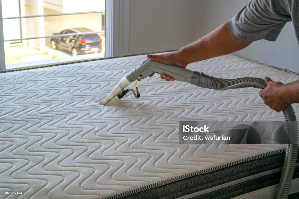 Cleaning the mattress. Photo of a person cleaning a mattress. Mattress Stock Photo