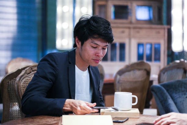 istock Young male looking at mug in cafe 1151592210