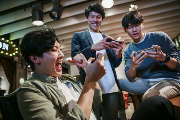 istock Young friends playing mobile game in cafe 1151593502