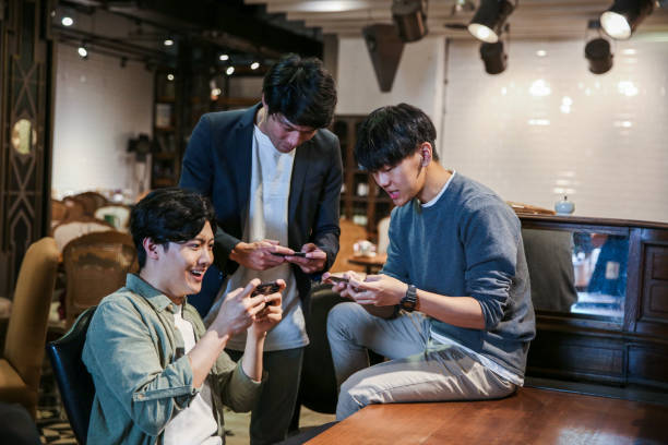 istock Young friends playing mobile game in cafe 1151593509