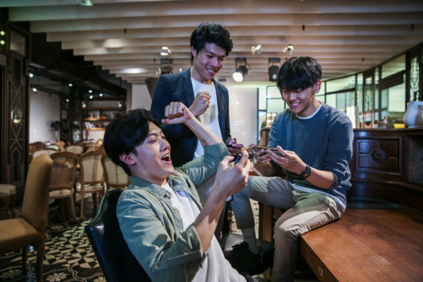 istock Young friends playing mobile game in cafe 1151593525