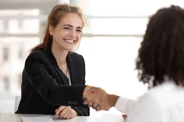 Photo of Happy businesswoman hr manager handshake hire candidate selling insurance services