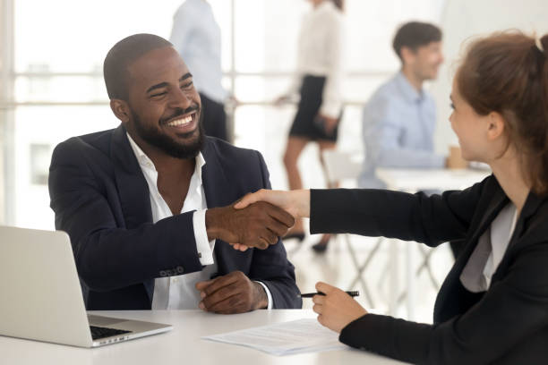 felice broker manager africano stretta di mano cliente caucasico a incontro - message communication sign african descent foto e immagini stock