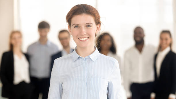 istock Young happy female leader looking in camera posing with team 1151593888