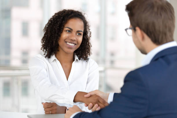 smiling african hr manager handshake hire candidate at job interview - new greetings imagens e fotografias de stock