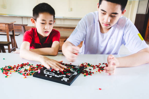 istock Boys are concentrate and focus on playing plastic block bricks 1151594070