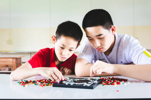 Boys are concentrate and focus on playing plastic block bricks