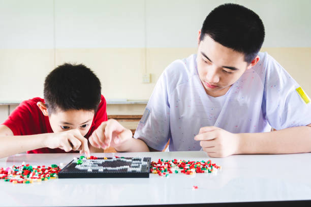 istock Boys are concentrate and focus on playing plastic block bricks 1151594122