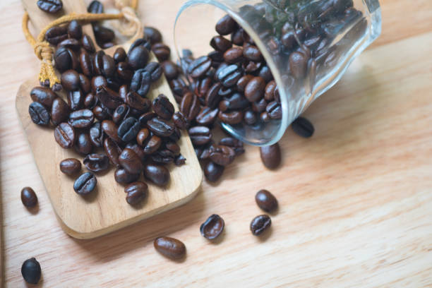 istock Pile of medium or dark roasted coffee beans on wood table 1151595746