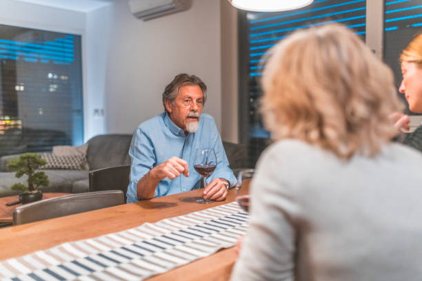 istock Senior man talking with women at dining table 1151597641