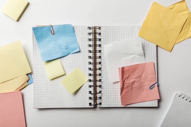 istock top view of opened notebook with squared papers and crumpled sticky notes on white background 1151599230