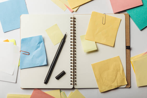 istock top view of opened notebook with sticky notes with paper clips and black pen on white background 1151599233