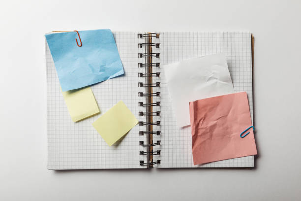 istock top view of opened notebook with squared papers and sticky notes on white background 1151599241