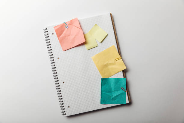istock top view of notebook with blank squared page near crumpled sticky notes on white background 1151599261