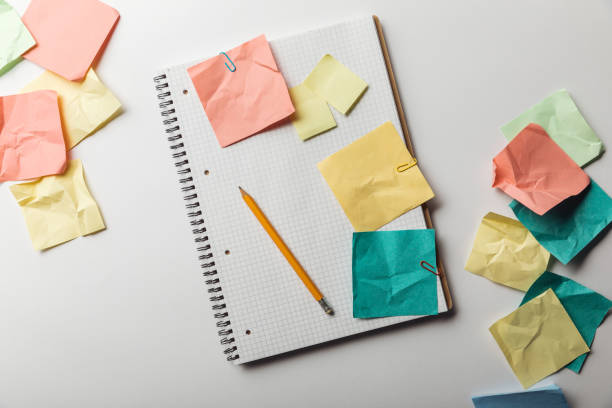 istock top view of notebook with blank squared page near crumpled colorful sticky notes on white background 1151599276