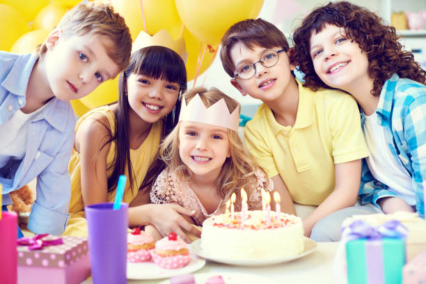 istock Smiling kids with birthday cake looking at camera 1151602601